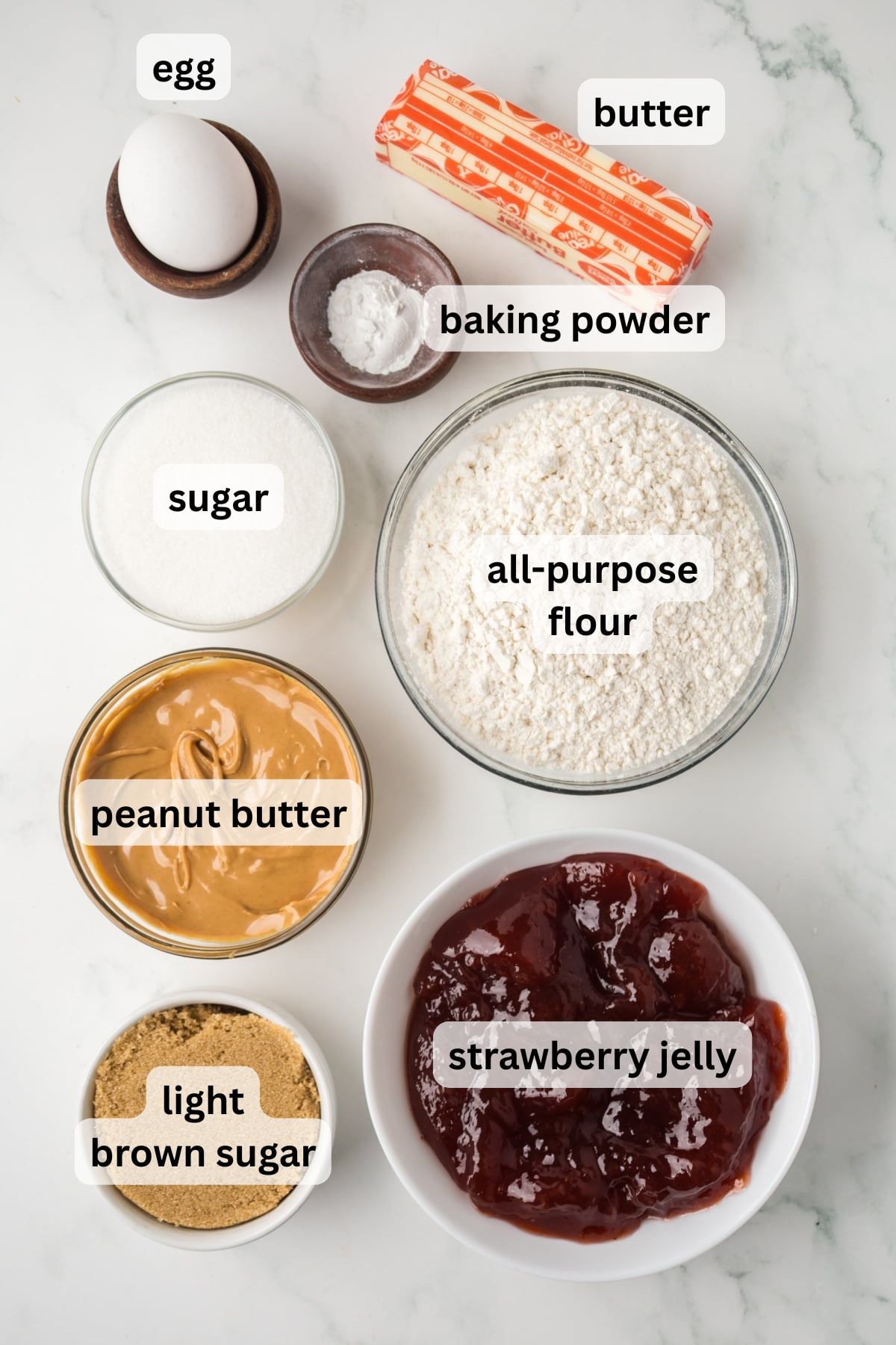 All the ingredients needed to make PB&J Cobbler in bowls on a table