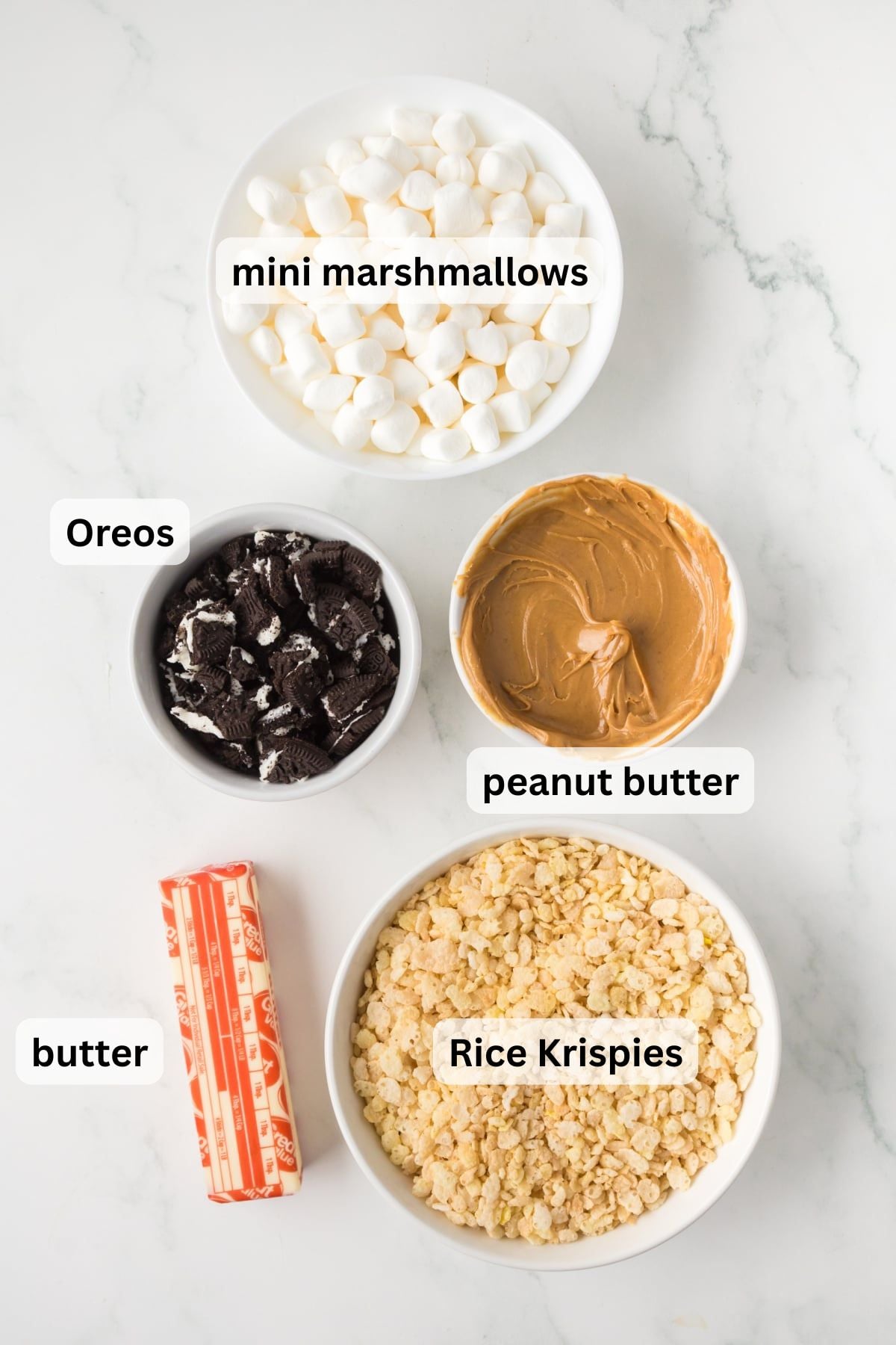 All the ingredients needed to make Peanut Butter Oreo Rice Krispie Treats in bowls on a table