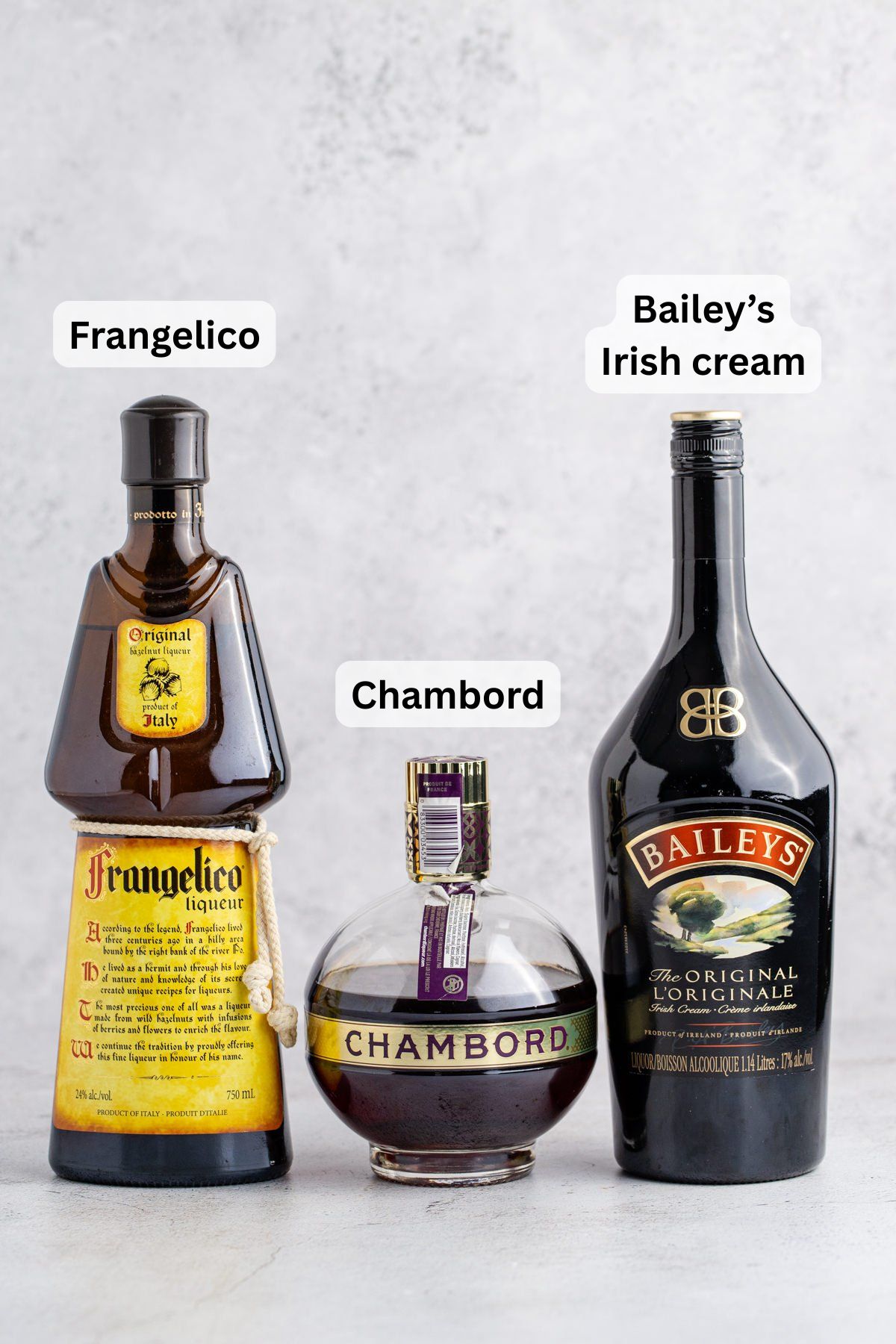 All of the ingredients needed to make a peanut butter and jelly shot in three bottles on a table.