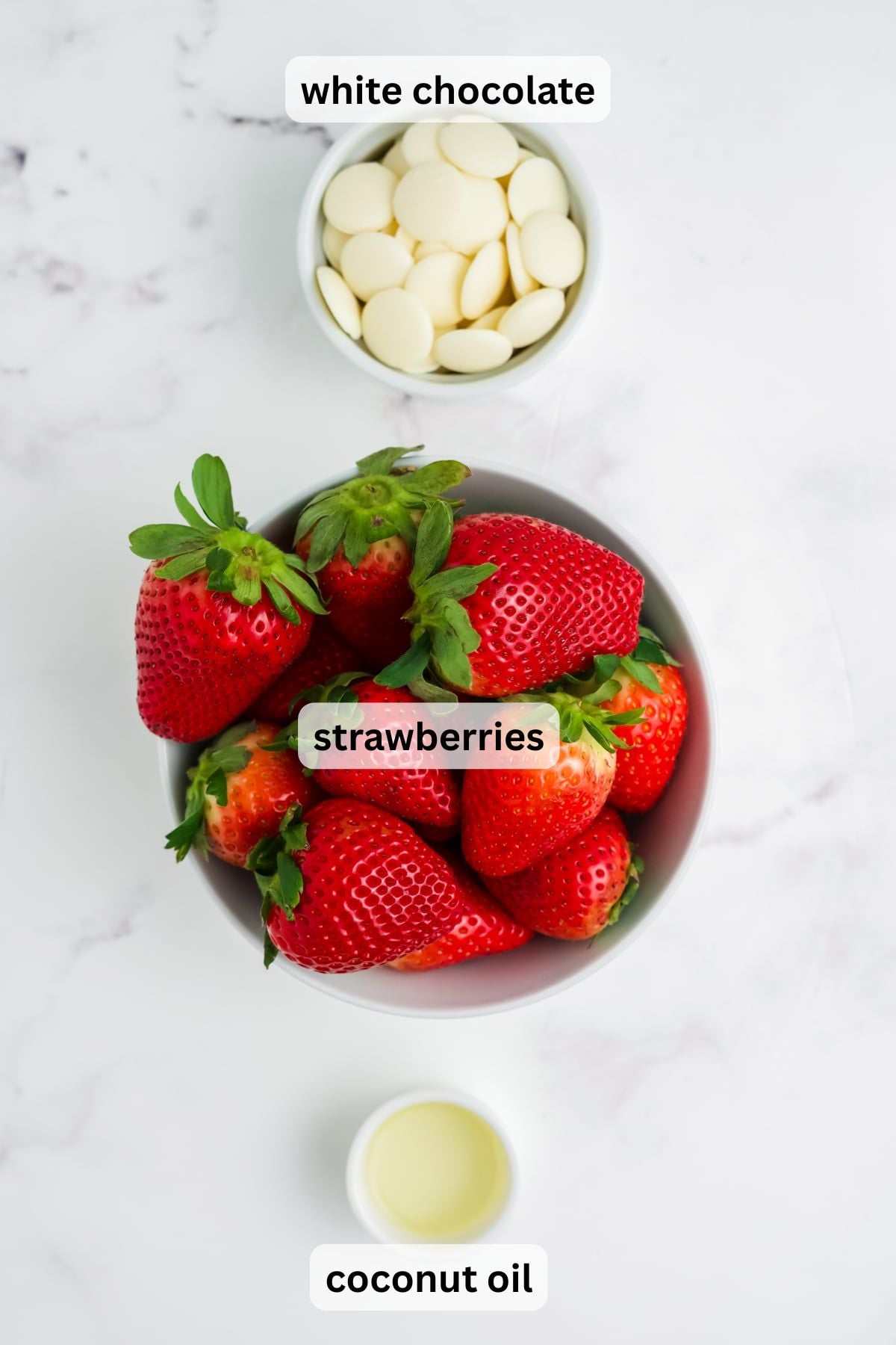 All the ingredients needed to make these strawberries in bowls on a table.