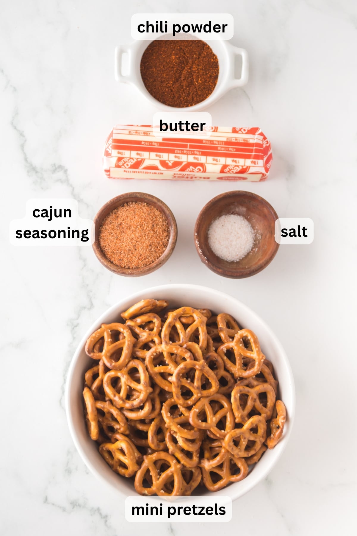 ingredients for cajun pretzels including butter cajun seasoning and pretzels in bowls on a table