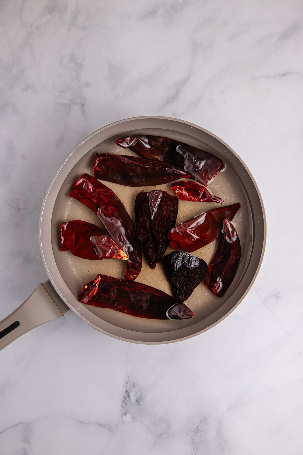 Dried ancho and guajillo chiles in a saucepan.