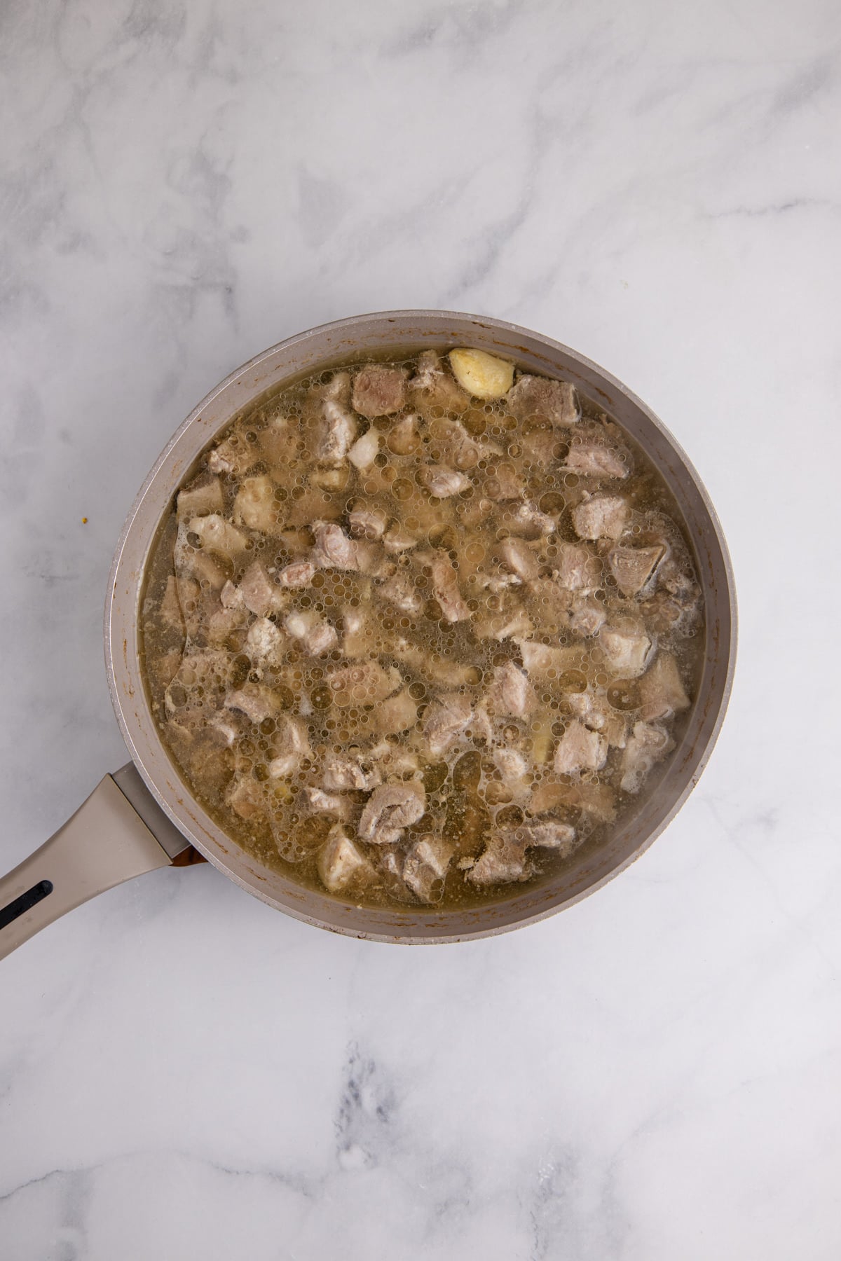 The pork and water added to the pan.