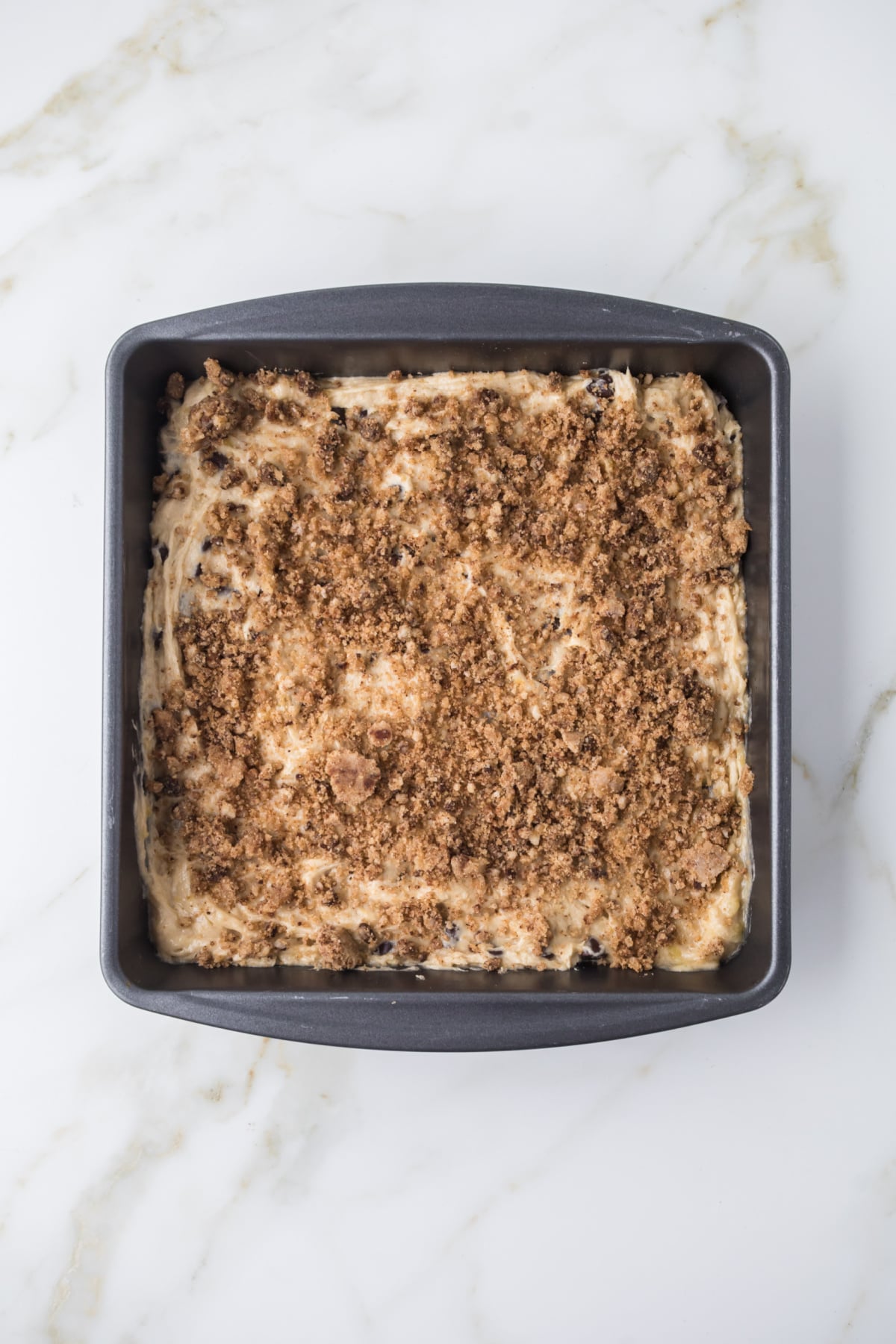 banana bread cake batter spread evenly in baking dish with topping
