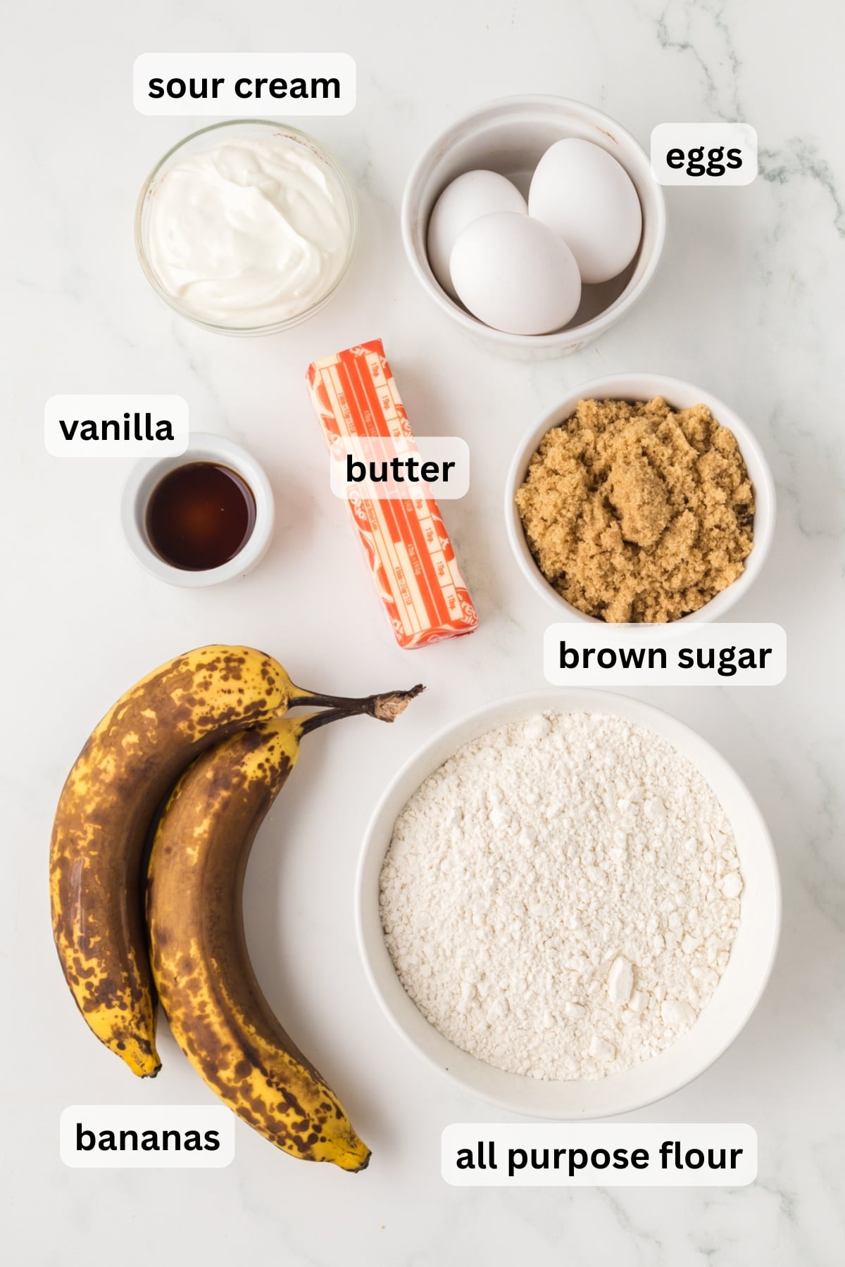 ingredients for banana coffee cake including bananas flour sugar butter and cinnamon in bowls on a table
