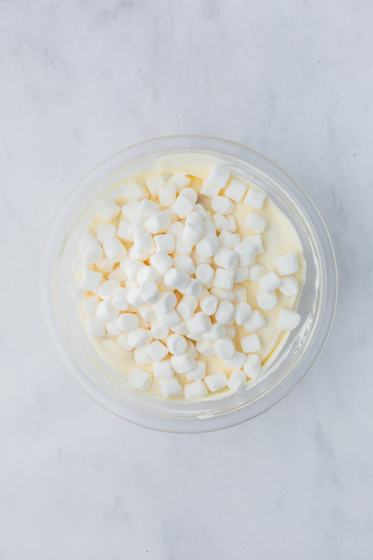 adding marshmallows to fluff in the bowl 