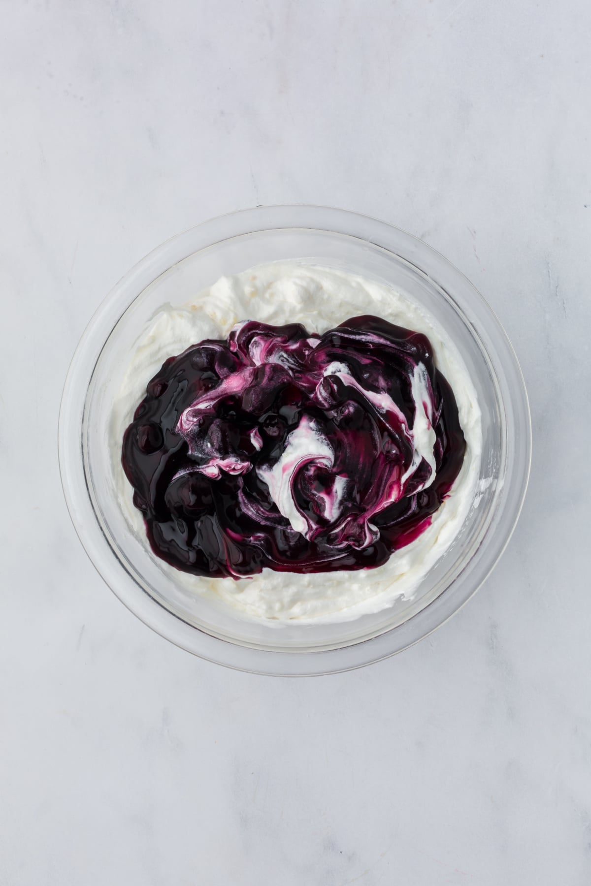 adding blueberry pie filling to fluff mixture in bowl