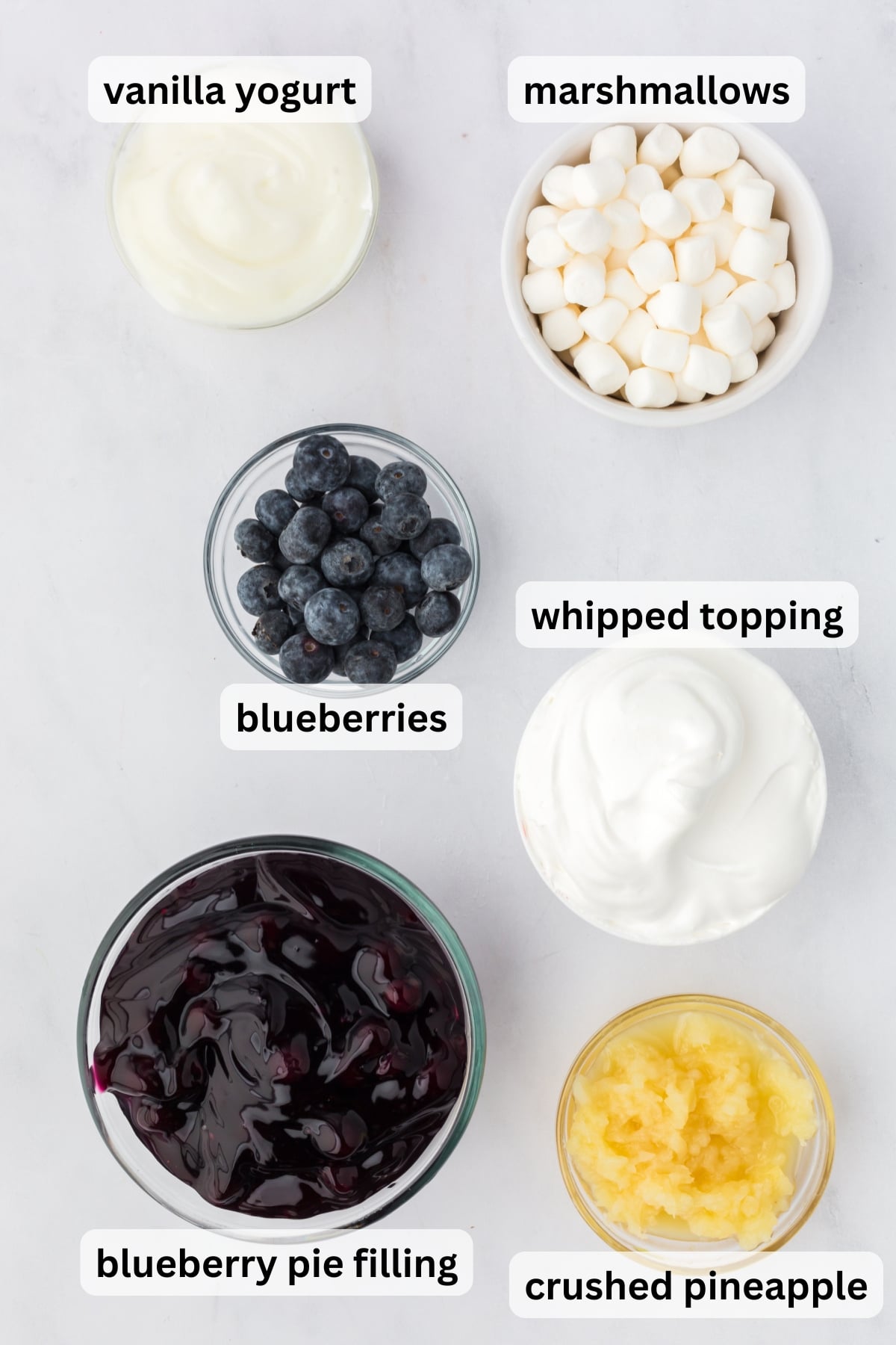 ingredients for blueberry fluff recipe including pie filling pineapple marshmallows and whipped topping