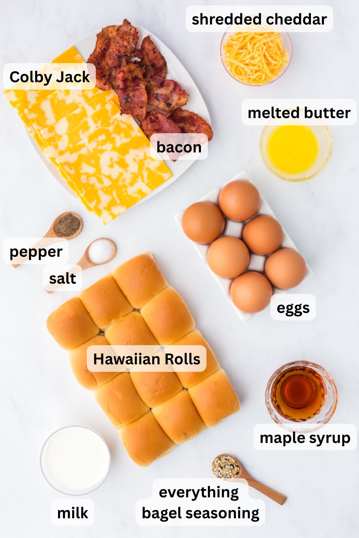 ingredients for breakfast sliders including eggs bacon cheese hawaiian rolls and butter on a table