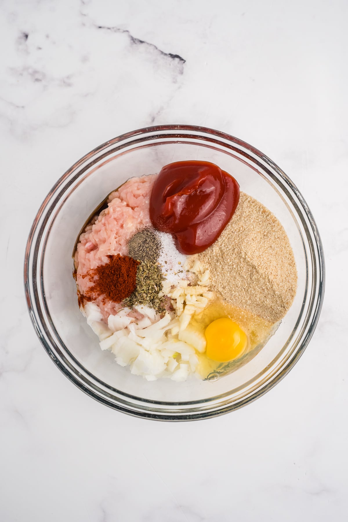 Ingredients to make chicken meatloaf added to a bowl. 