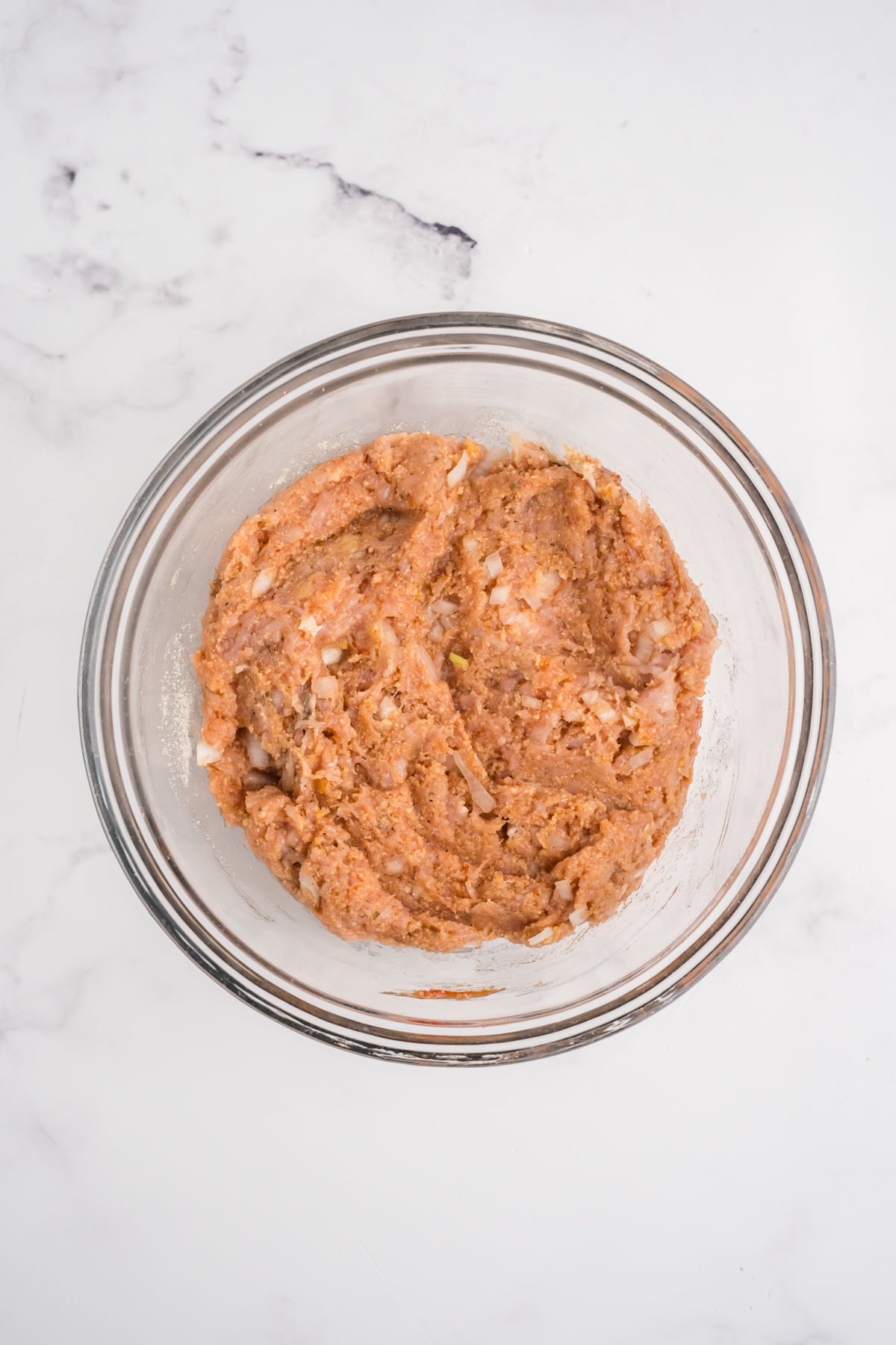 Ground chicken meatloaf mixed in a bowl. 