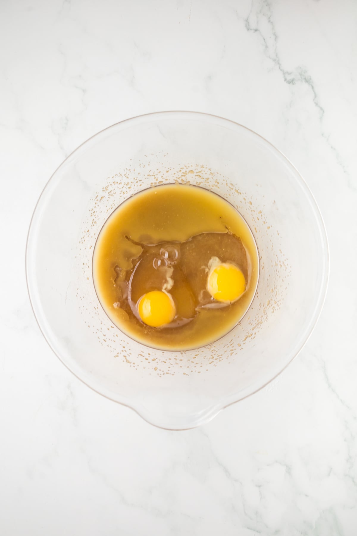 Melted butter, and sugar and eggs in mixing bowl for double chocolate chip muffins recipe