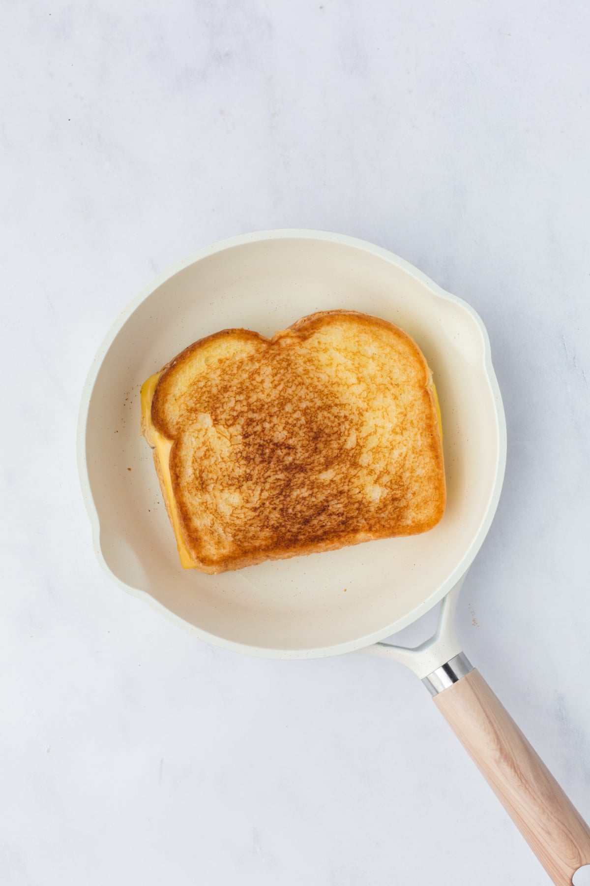 golden brown sandwich in skillet 