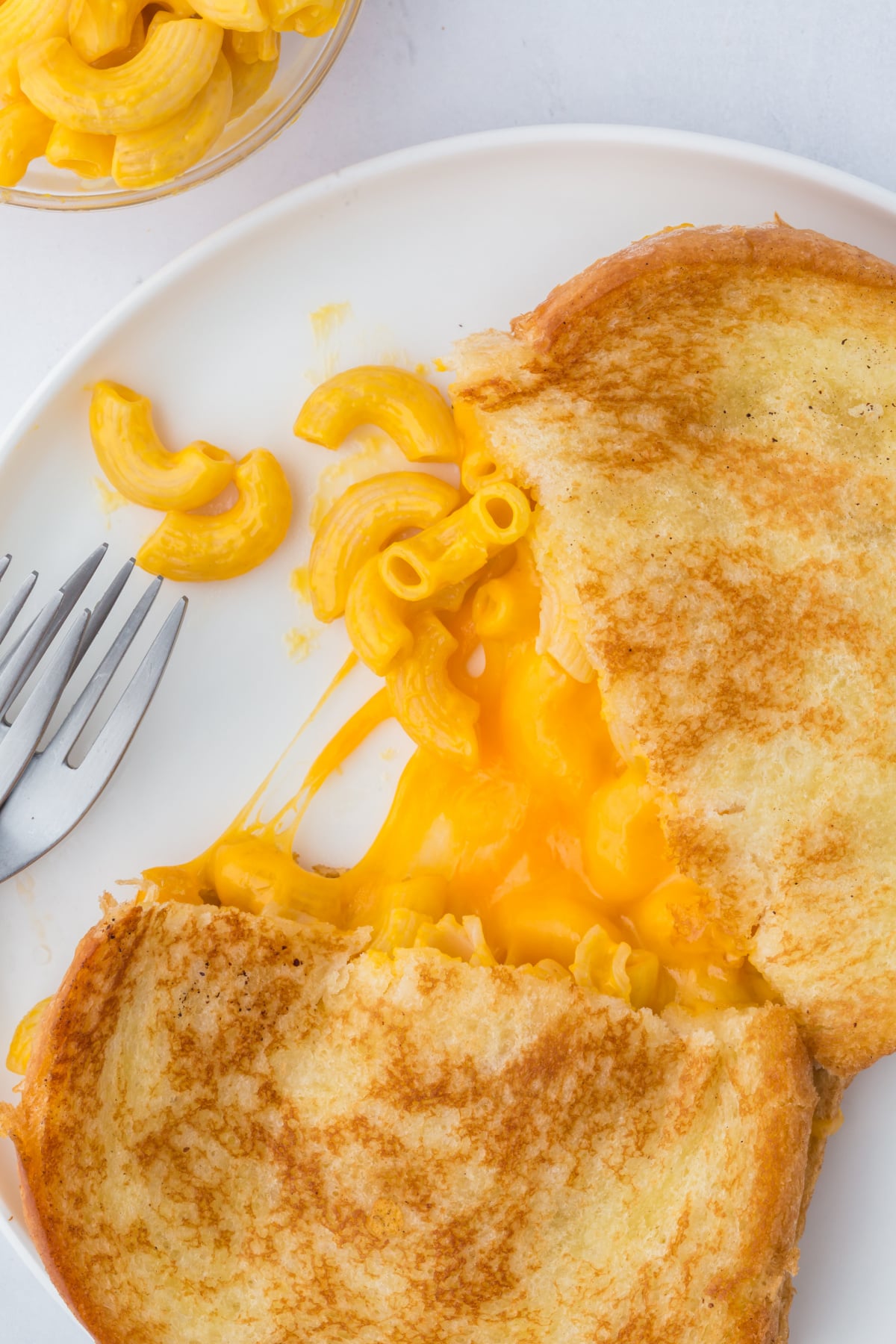 A grilled mac and cheese cut in half on a plate