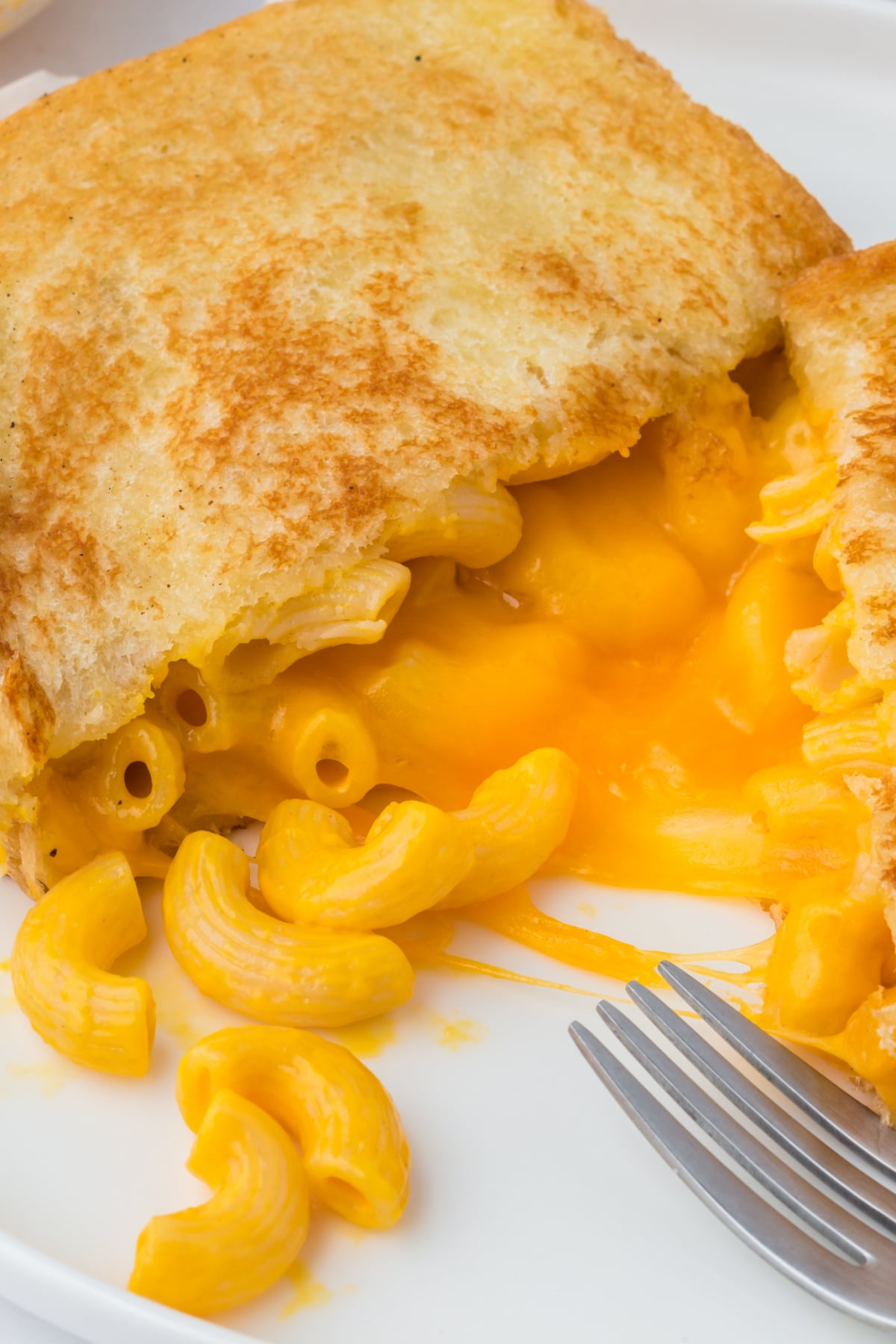Half a grilled mac and cheese sandwich on a plate