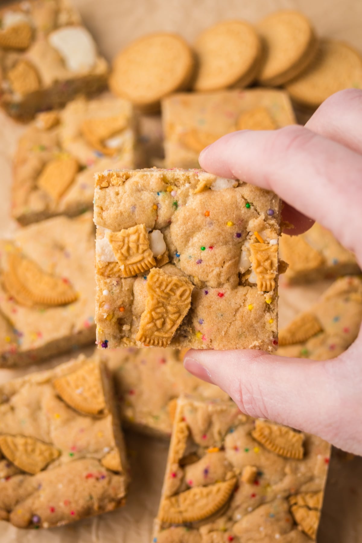 oreo cookie bar held in the air showing soft center and oreo pieces