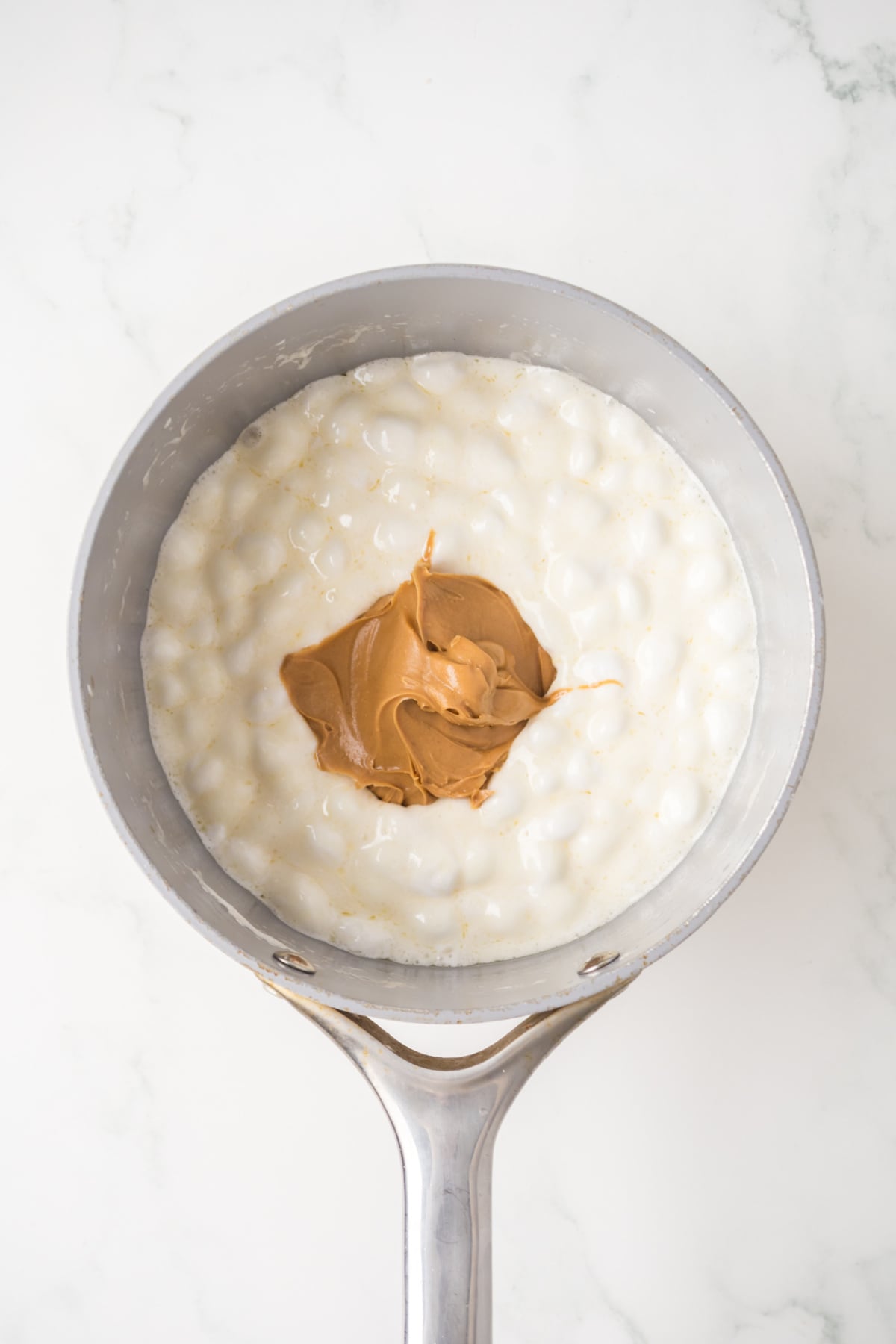 melting marshmallows and peanut butter for rice krispie treats in saucepan