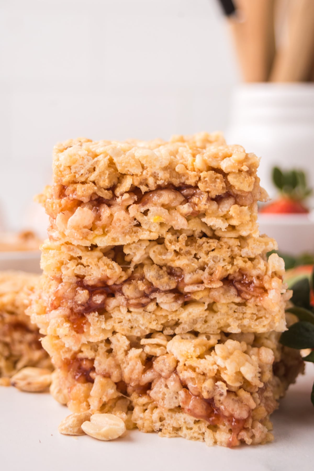 stacked peanut butter jelly rice krispie treats ready to serve on a counter