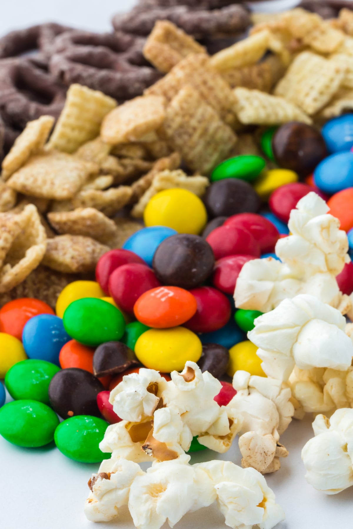rows of popcorn, chocolate pretzels, cereal and M&M's on a counter