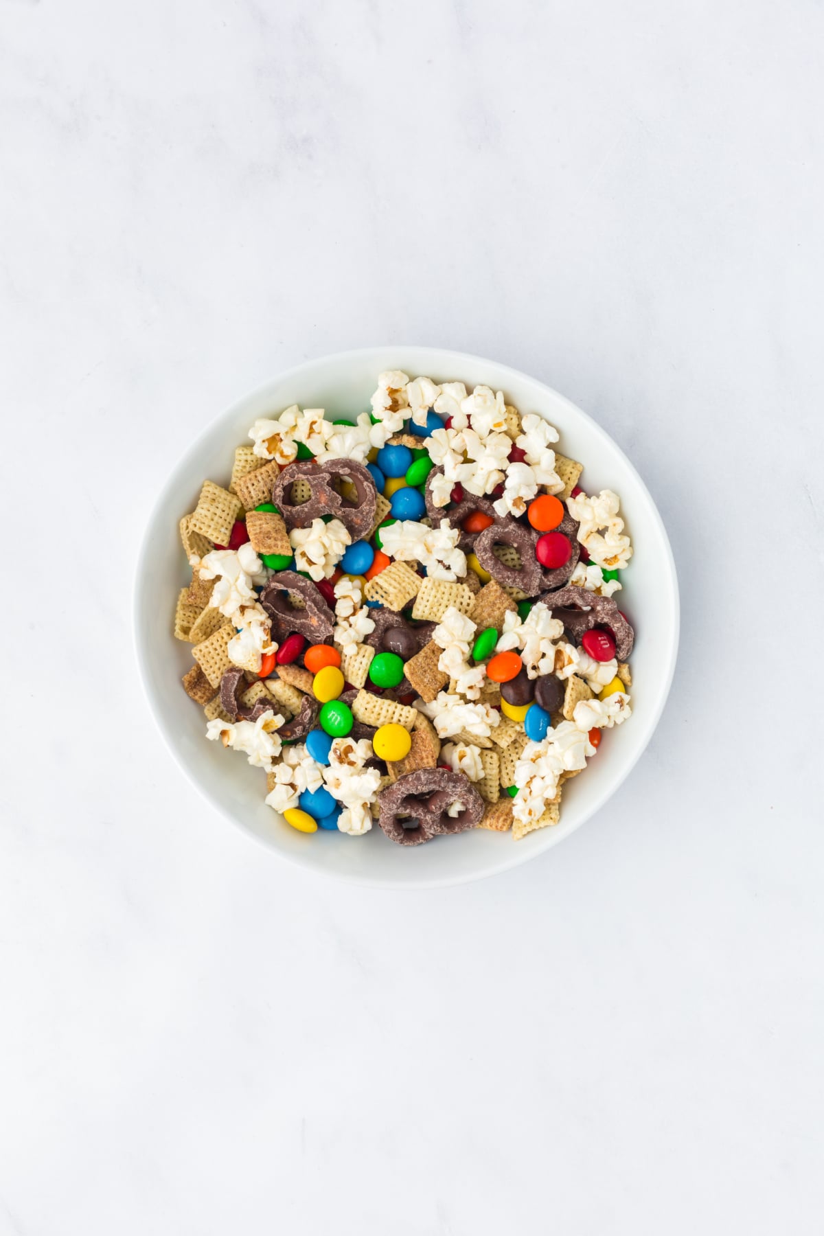 popcorn trail mix ingredients tossed together in a large bowl