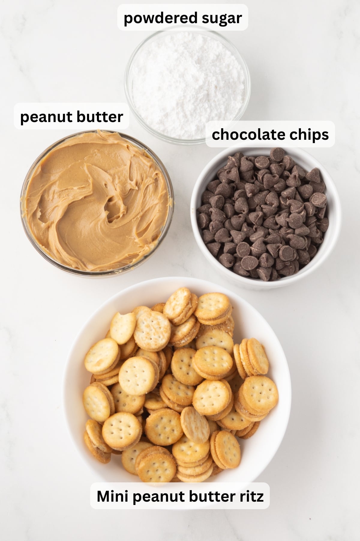 ingredients for ritz muddy buddies including chocolate chips peanut butter ritz crackers and powdered sugar in bowls on a table