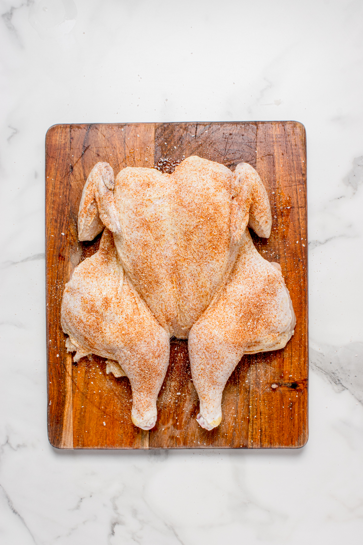 The chicken flipped over and flattened against the cutting board.