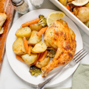 Roasted spatchcock chicken on a plate with a side of veggies.