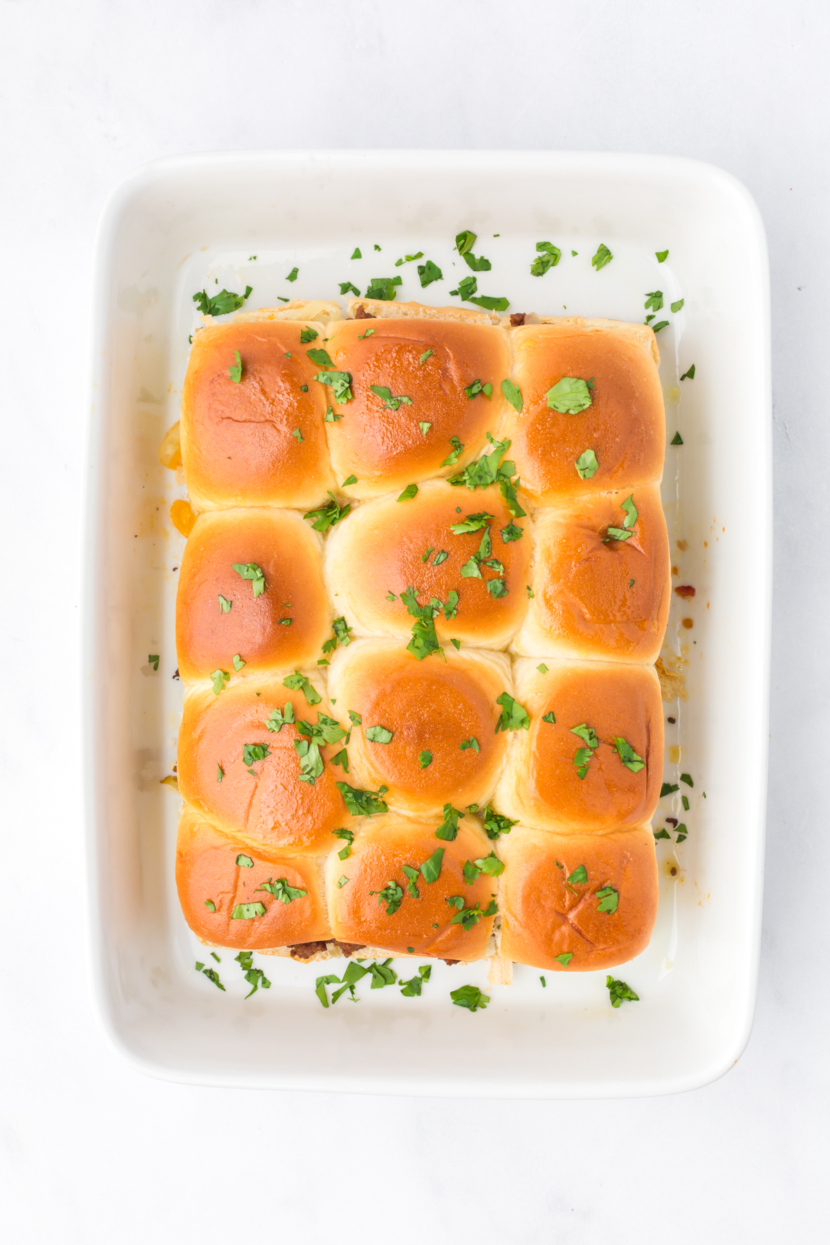 Baked sliders with cilantro sprinkled on top.