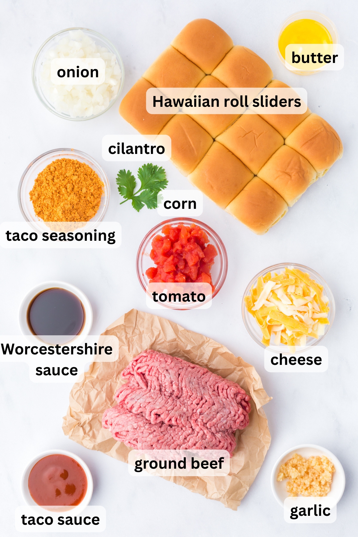 All of the ingredients you need to make Taco Sliders in bowls on a table.
