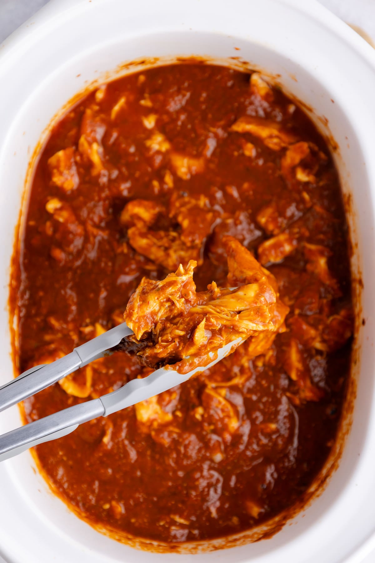 The shredded chicken and sauce in the slow cooker.