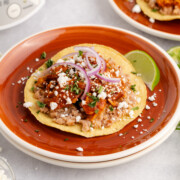 Chicken tinga on a red plate.