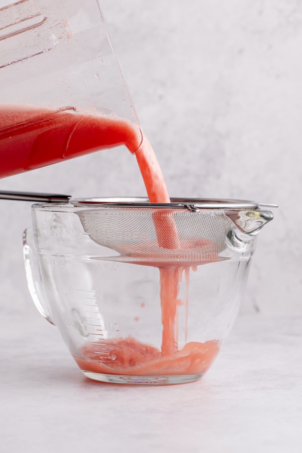 Agua fresca mixture through a fine mesh strainer.