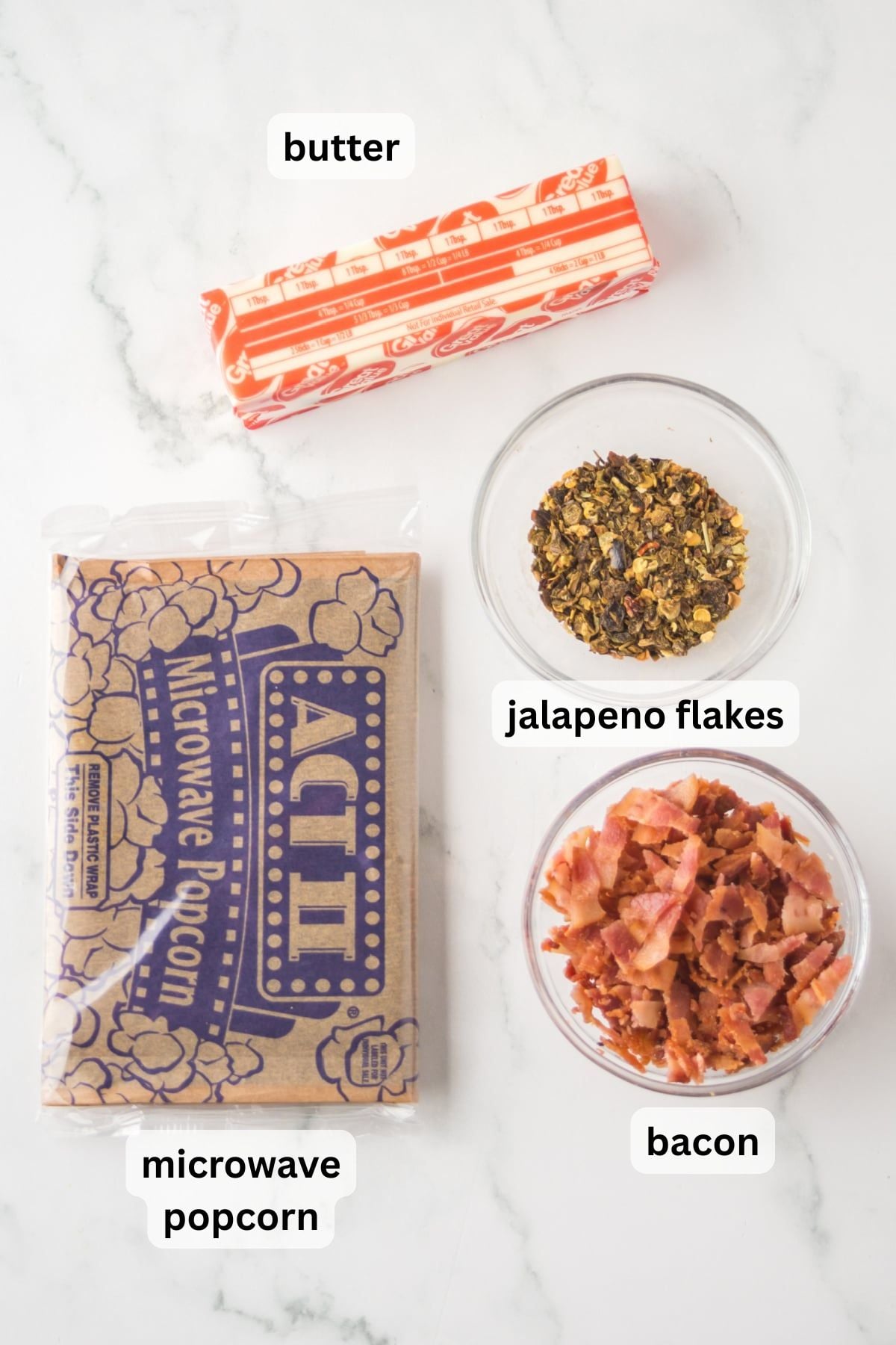 All the ingredients needed to make Bacon Popcorn in bowls on a table