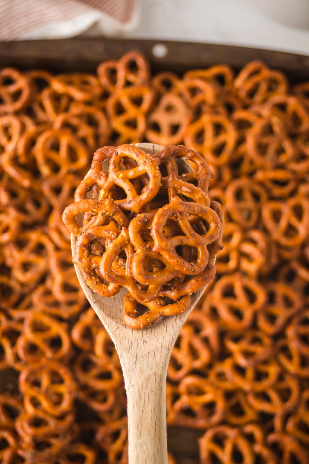 a wooden spoonful of homemade cajun pretzels crispy and seasoned held in the air