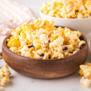 Cheddar cheese popcorn in a wooden bowl on a table.
