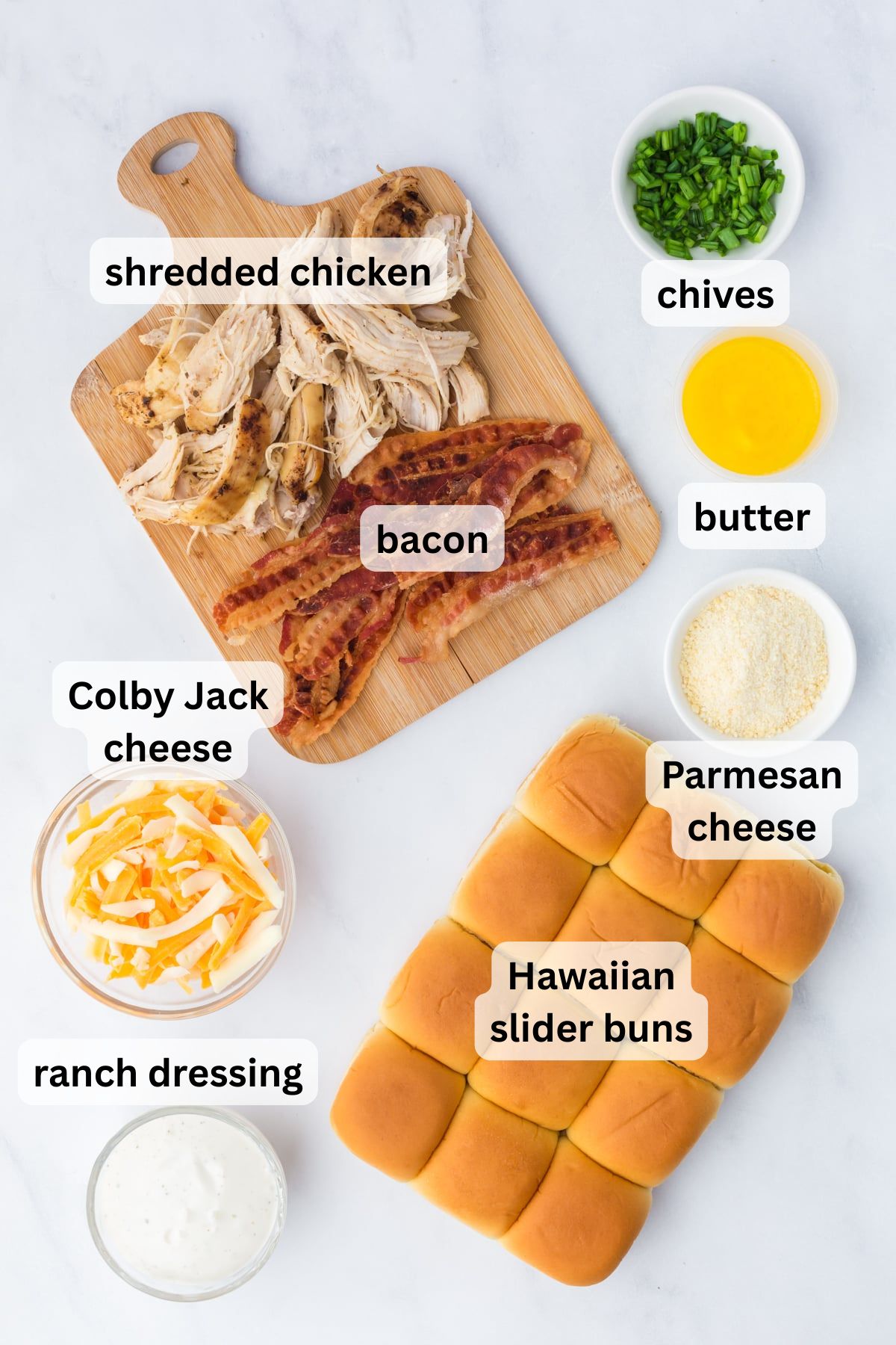 Ingredients to make these chicken and bacon sliders in bowls on a table.