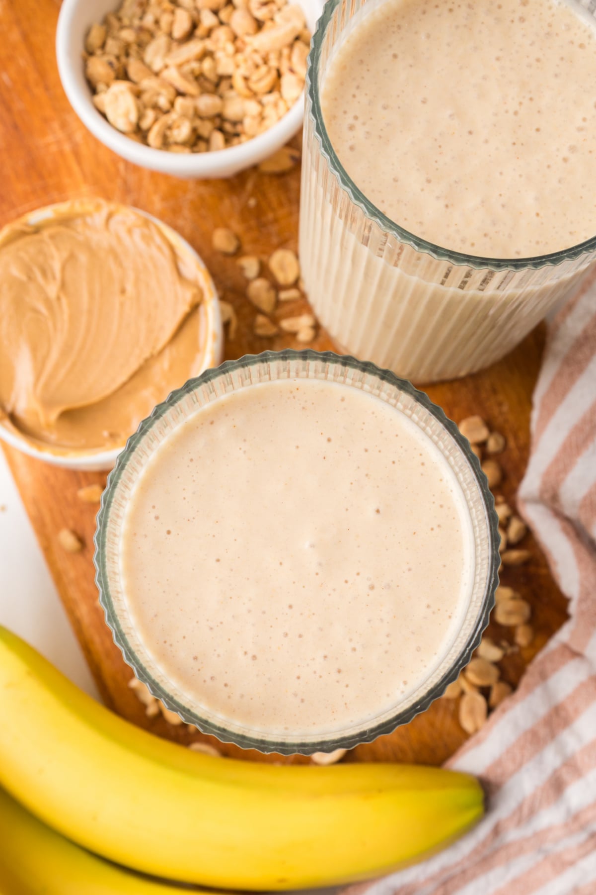 Two banana peanut butter smoothies in glass on table
