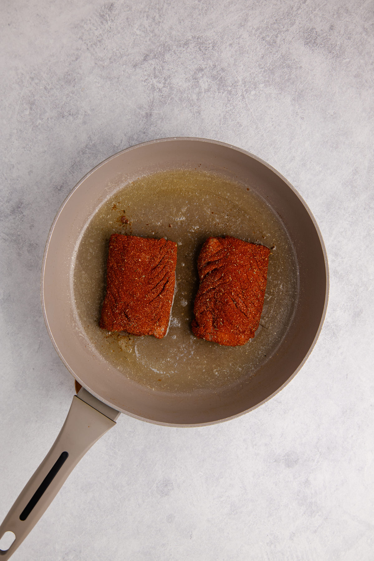 Cod in a pan with blackening seasoning blend.