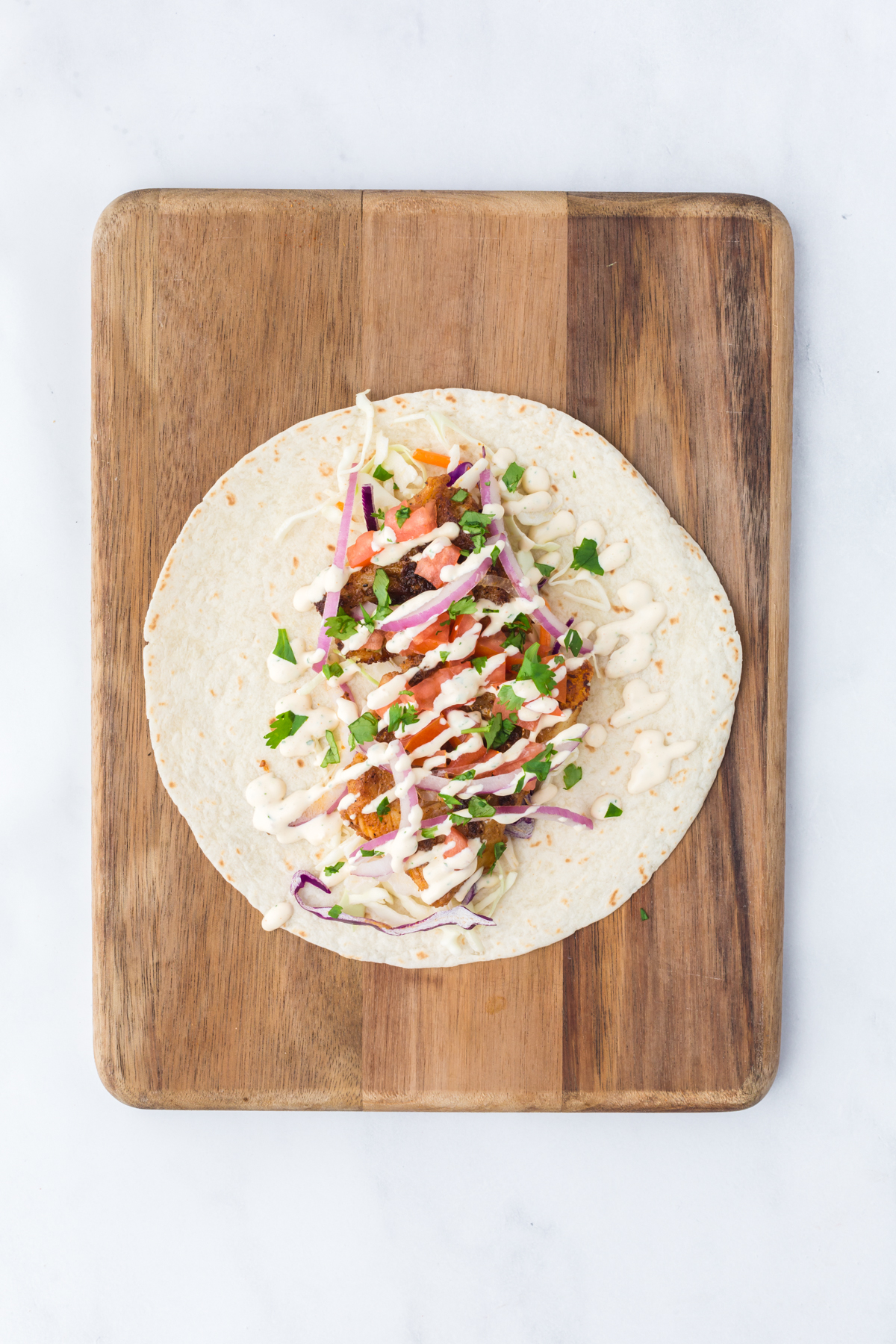 Red onion and fish taco sauce drizzled on top of the taco.