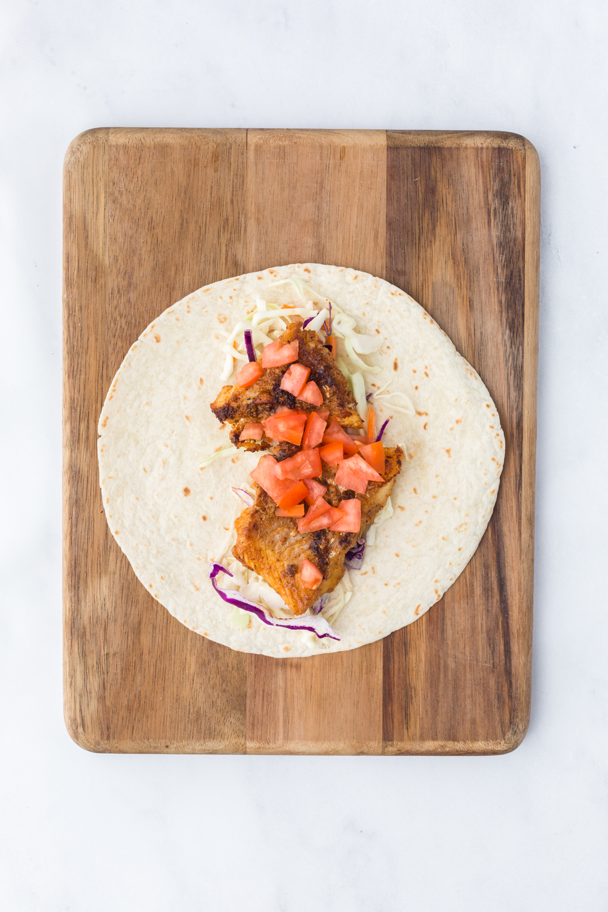 Coleslaw mix, fish and salsa on a tortilla.