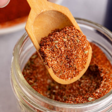 Blackening seasoning being scooped out of the jar.