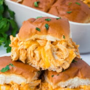 Baked Buffalo Chicken Sliders in dish with one on top