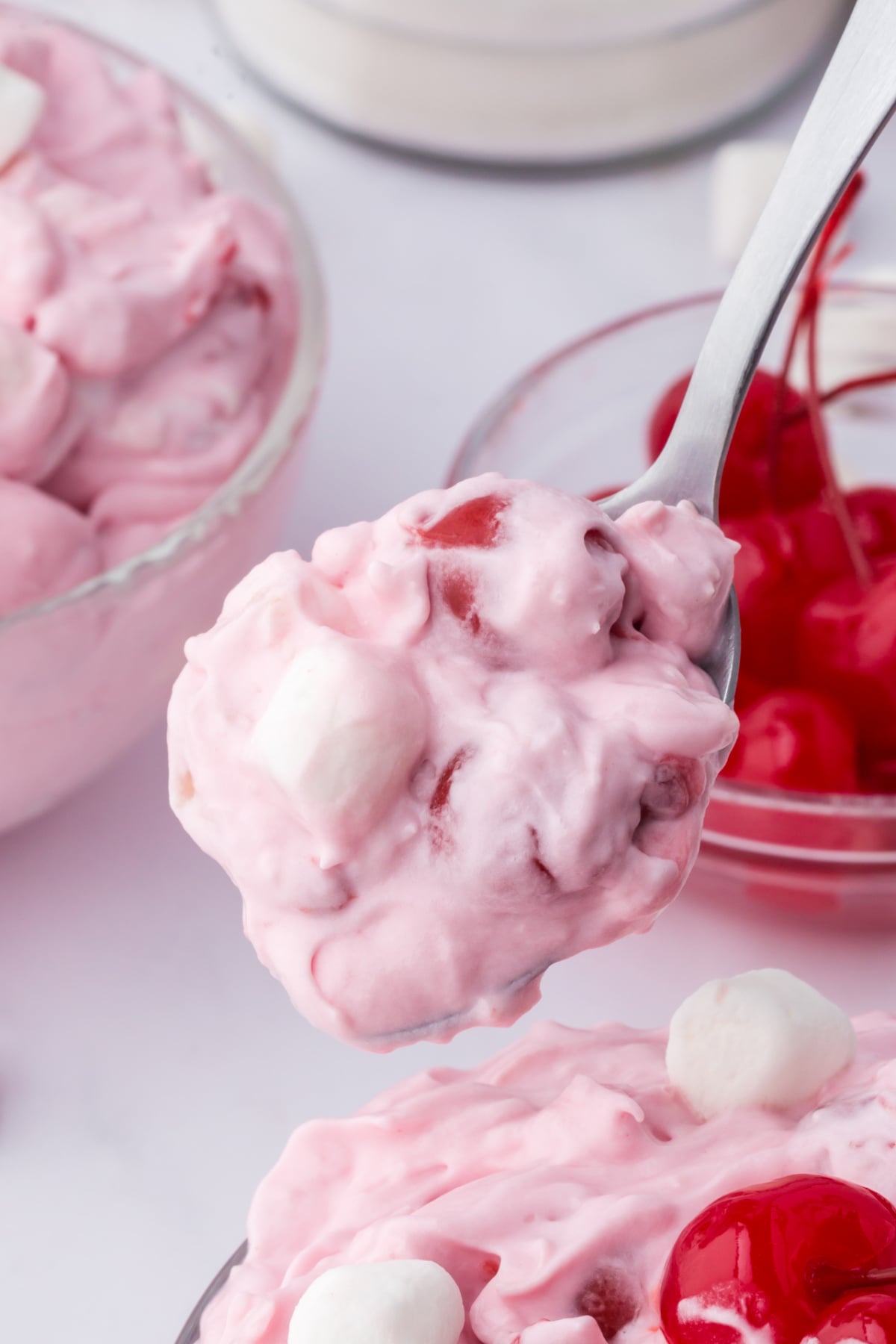 A spoonful of cherry fluff held in the air.