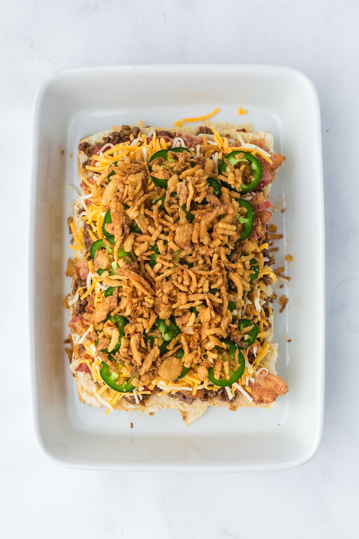 More optional cheese added, jalapenos and crispy onions on top of ground beef and bacon.