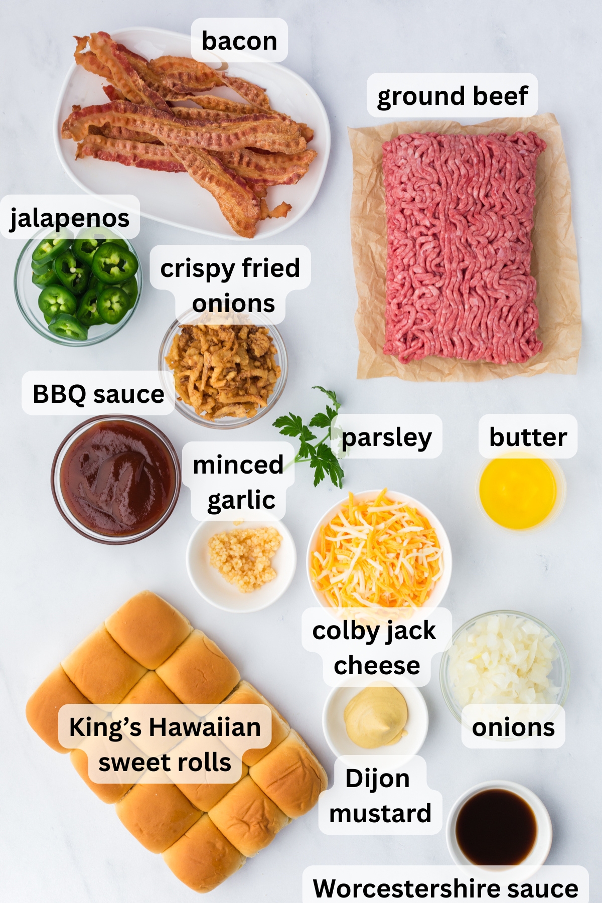 All of the ingredients needed to make cowboy sliders in bowls on a table.