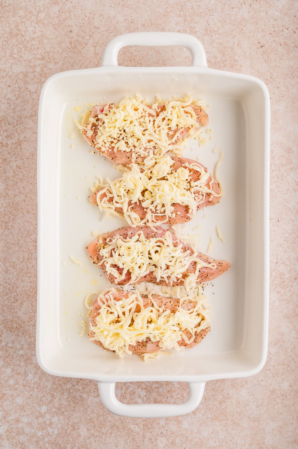 shredded mozzarella added to top of each chicken breast in baking dish