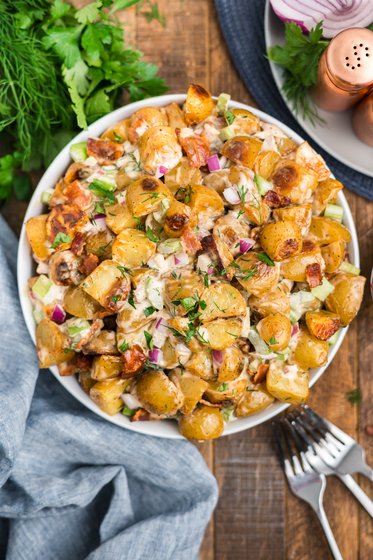 tossed salad in a bowl with a sprinkling of bacon and fresh herbs