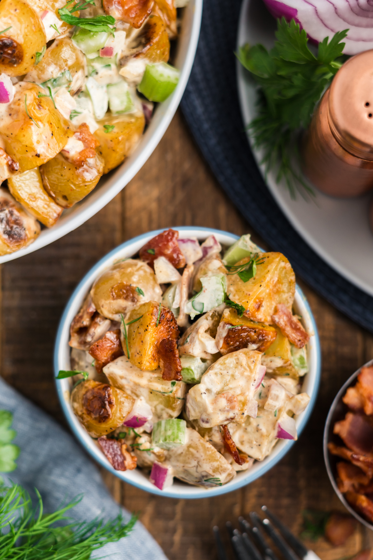 A bowl of roasted potato salad on a table.