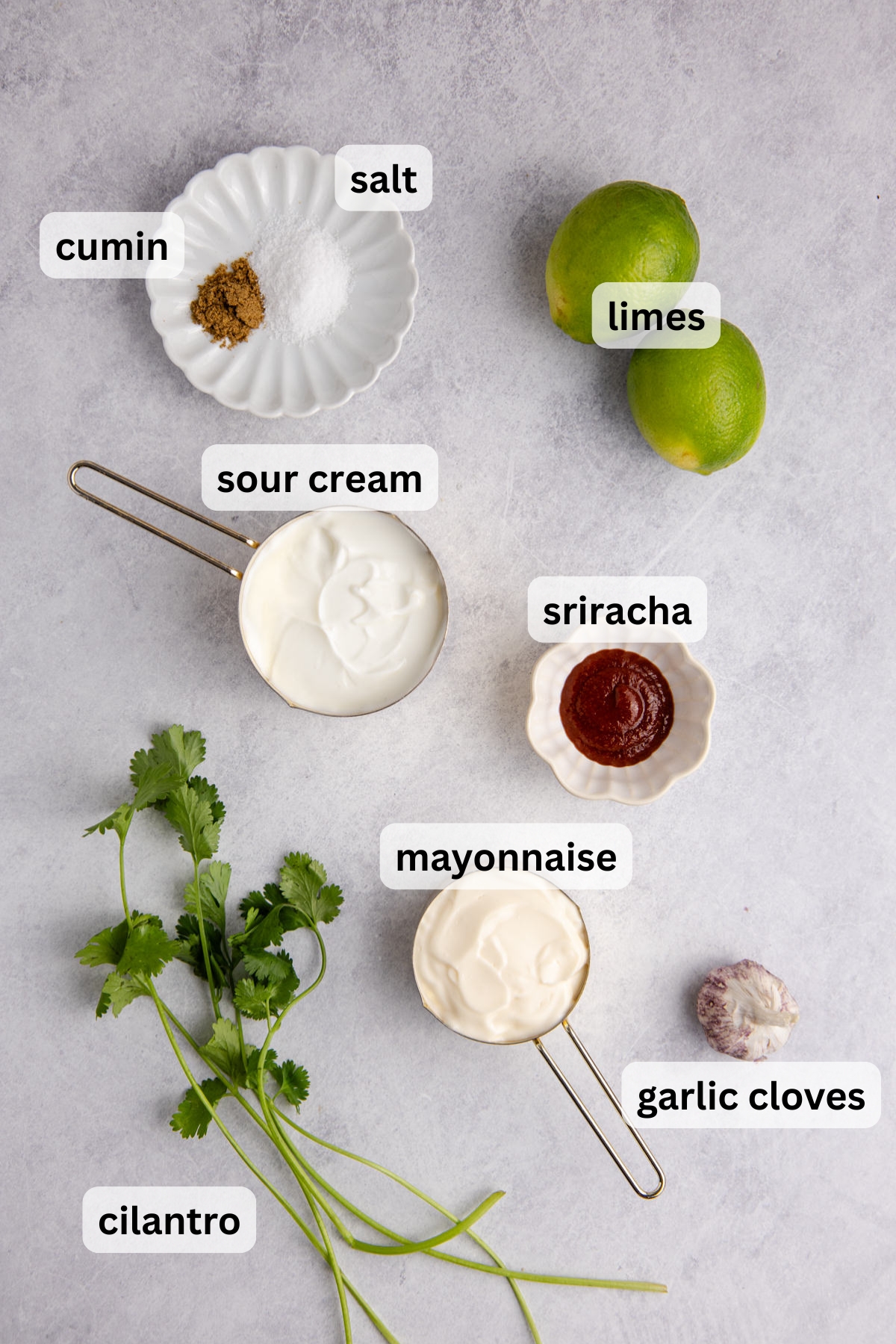 Ingredients to make this fish taco sauce in bowls on a table.
