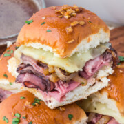 French dip sliders in casserole dish with one on top.